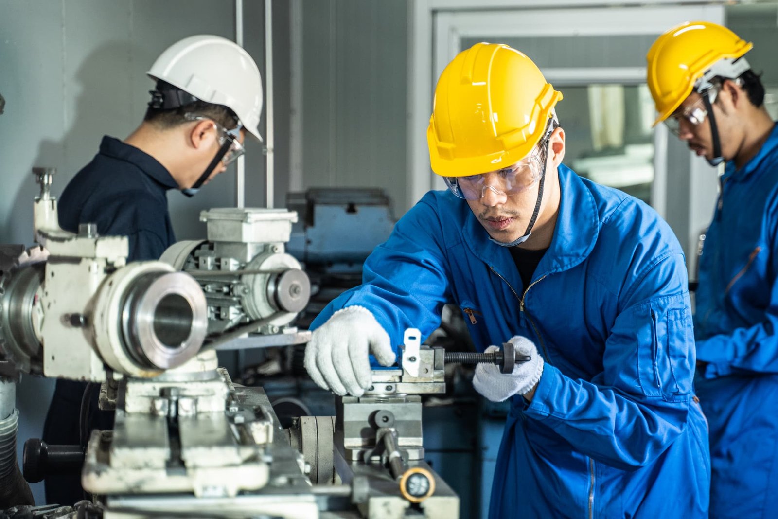 Technicians working on machinery in an industrial workshop